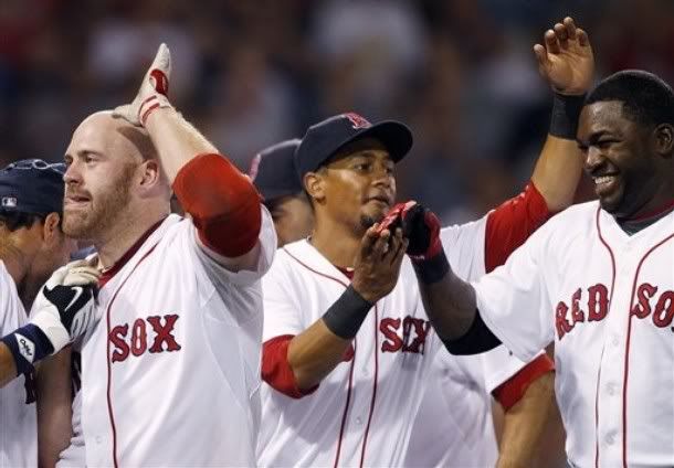 Boston  Red Sox's Kevin Youkilis, left, celebrates with teammates Eric Patterson, center, and David Ortiz, right, after hitting a sacrifice fly that allowed the winning run to score in the eleventh inning of a baseball game against the Texas Rangers, Saturday, July 17, 2010, in Boston. The Red Sox won 3-2.