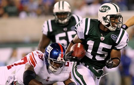 Larry Taylor #15 of the New York Jets breaks a tackle from D.J. Johnson #28 of the New York Giants during their game at New Meadowlands Stadium on August 16, 2010 in East Rutherford, New Jersey.