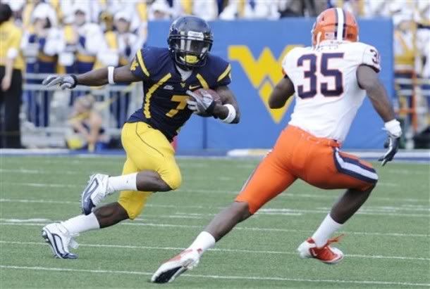 West Virginia's Noel Devine looks for running room past Syracuse's Mike Holmes during an NCAA college football game, Saturday, Oct. 23, 2010, in Morgantown, W.Va.