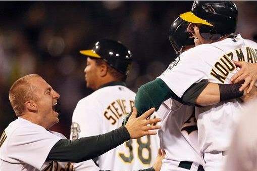 Oakland Athletics' Kevin Kouzmanoff, right, is congratulated by teammates including Cliff Pennington, left, after hitting the game-winning single during the tenth inning of a baseball game against the Boston Red Sox Tuesday, July 20, 2010, in Oakland, Calif. (AP Photo/Ben Margot)