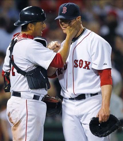 Boston Red Sox catcher Victor Martinez, left, gives pitcher Jon Lester a pat on the cheek after throwig a complete baseball game at Fenway Park in Boston, Thursday, May 20, 2010. Lester allowed one earned run on six hits in his outing.(AP Photo/Charles Krupa)