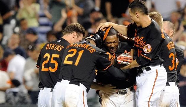 Miguel Tejada #9 of the Baltimore Orioles is mobbed by teammates after driving in the game winning run in the tenth inning against the Boston Red Sox at Camden Yards on April 30, 2010 in Baltimore, Maryland. The Orioles won the game 5-4. (Photo by Greg Fiume/Getty Images)