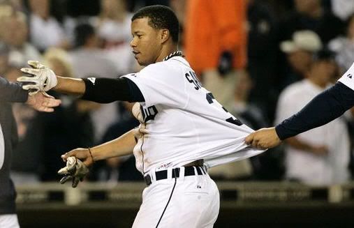 Detroit Tigers' Ramon Santiago has his jersey pulled by a teammate after he walked with the bases loaded to beat the Boston Red Sox 7-6 in the 12th inning of a baseball game Saturday, May 15, 2010 in Detroit. (AP Photo/Duane Burleson)