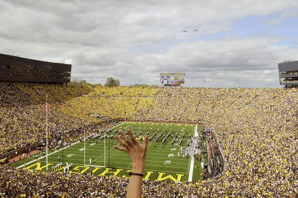  A fan reaches out to wave as a pair of A-10 Warthogs provided a fly-over during the re-dedication ceremonies at Michigan Stadium on Saturday afternoon.