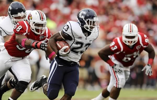 Jordan Todman of UConn escapes the grasp of Rodney Gnat of Louisville during the first quarter at Papa John's Cardinal Stadium in Louisville, KY.