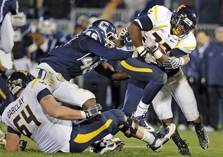 West Virginia's Ryan Clarke is tackled by UConn's Sio Moore, left, and Jerome Junior, background, during overtime. 