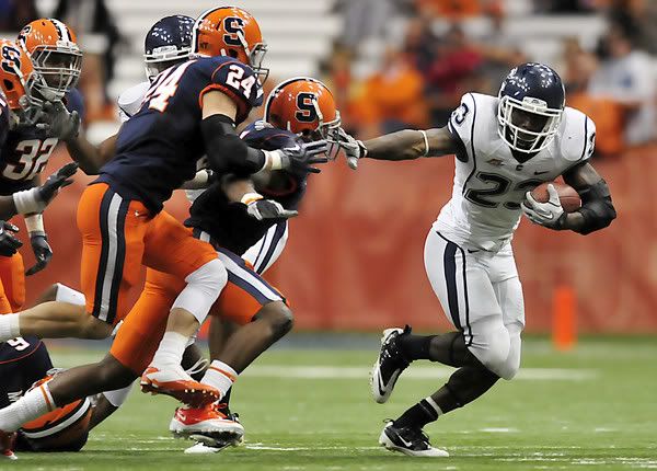 UConn's Jordan Todman runs around the defense of Syracuse's Doug Hogue, from left, Max Suter and Philip Thomas during the fourth quarter of UConn's 20-6 win Saturday. 