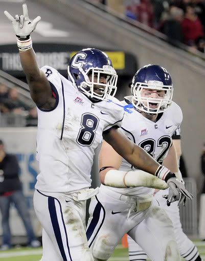 UConn's Lawrence Wilson celebrates with Scott Lutrus after making an interception for a touchdown in the second quarter to put the Huskies ahead 10-3 at the half during their football game against the University of South Florida at the Raymond James Stadium in Tampa Saturday for the last game of the regular season. The hand sign is a 'Little Haiti' for Jasper Howard. 