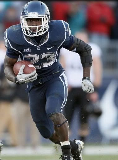 Jordan Todman #23 of the Connecticut Huskies carries the ball around the Cincinnati Bearcats defense on November 27, 2010 at Rentschler Field in East Hartford, Connecticut. The Huskies defeated the Bearcats 38-17.