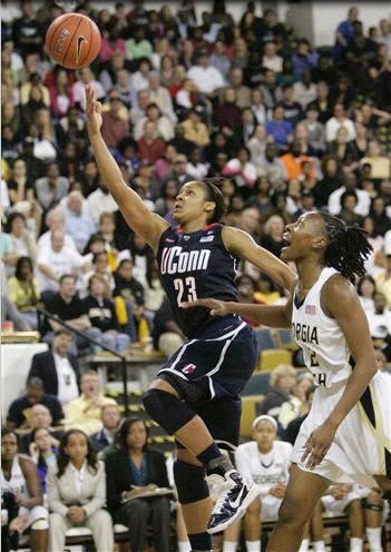 Connecticut forward Maya Moore (23) takes the ball to the basket past Georgia Tech guard Mo Bennett during the first half of an NCAA basketball game, Sunday, Nov. 21, 2010, in Atlanta. Connecticut won 71-51. Moore scored 30 points in her homecoming to Atlanta, leading No. 1 Connecticut to its 81st consecutive victory.