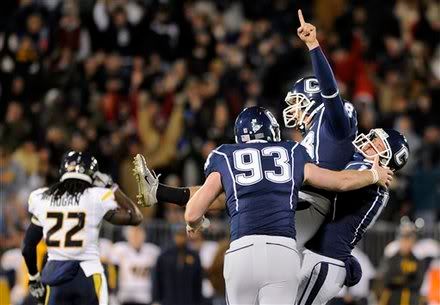 Connecticut's Dave Teggart, center, celebrates with Derek Chard, left, and Chad Christen after kicking the winning field goal in the overtime period of their 16-13 victory over West Virginia in their NCAA football game in East Hartford, Conn., on Friday, Oct. 29, 2010. In the background West Virginia's Brandon Hogan walks off the field.