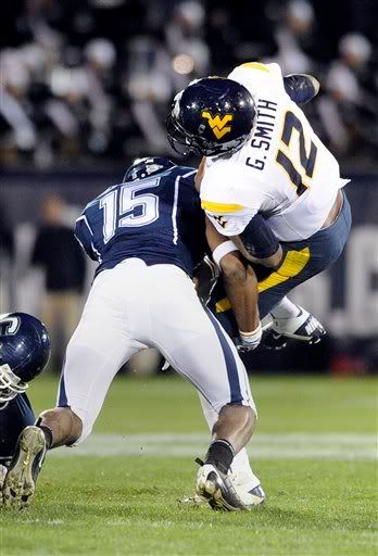 West Virginia's Geno Smith is sacked by Connecticut's Jerome Junior late in the fourth quarter of Connecticut's 16-13 overtime victory in their NCAA football game in East Hartford, Conn., on Friday, Oct. 29, 2010.