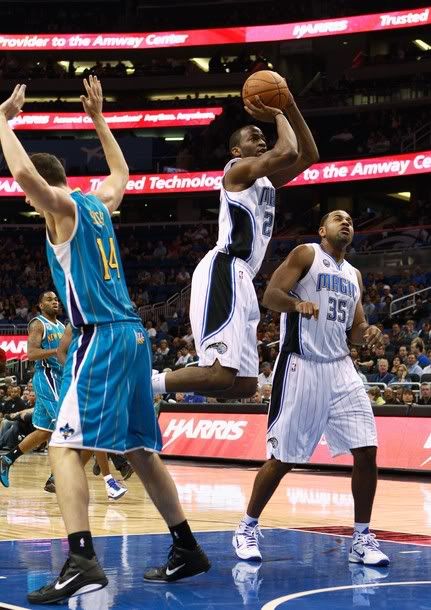 Stanley Robinson #24 of the Orlando Magic attempts a shot over Jason Smith #14 of the New Orleans Hornets during the game at Amway Arena on October 10, 2010 in Orlando, Florida.