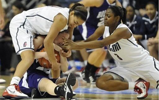 Connecticut's Bria Hartley, left, and Tiffany Hayes, right, pressure Holy Cross' Alex Smith, center, in the first half of an NCAA women's college basketball game in Storrs, Conn., Sunday, Nov. 13, 2011.