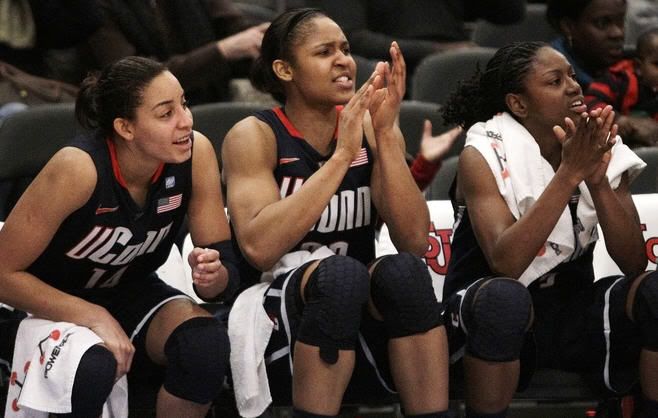 Connecticut’s from left, Bria Hartley, Maya Moore and Tiffany Hayes cheer on their teammates from the bench during the second half of an NCAA college basketball game against St. John’s, Wednesday, Jan. 12, 2011, in New York. Connecticut won 84-52.