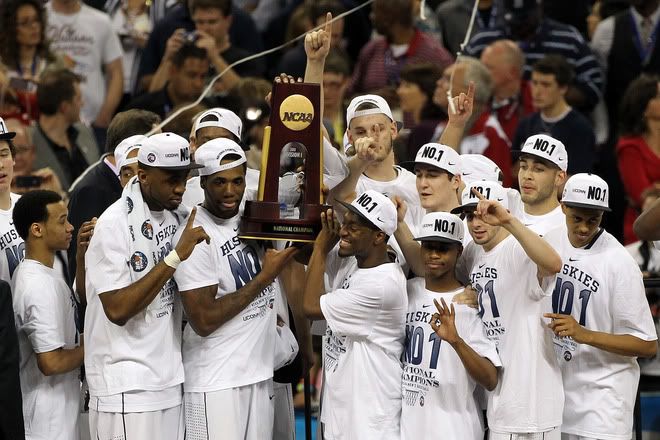 Kemba Walker #15, Alex Oriakhi #34 and Charles Okwandu #35 of the Connecticut Huskies celebrate with the trophy after defeating the Butler Bulldogs to win the National Championship Game of the 2011 NCAA Division I Men's Basketball Tournament by a score of 53-41 at Reliant Stadium on April 4, 2011 in Houston, Texas.