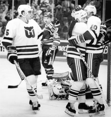 Kevin Dineen gets victory hug from Ron Francis after making first goal in first period. He would score again, within minutes. Ulf Samuelson from left comes in to congratulate him.