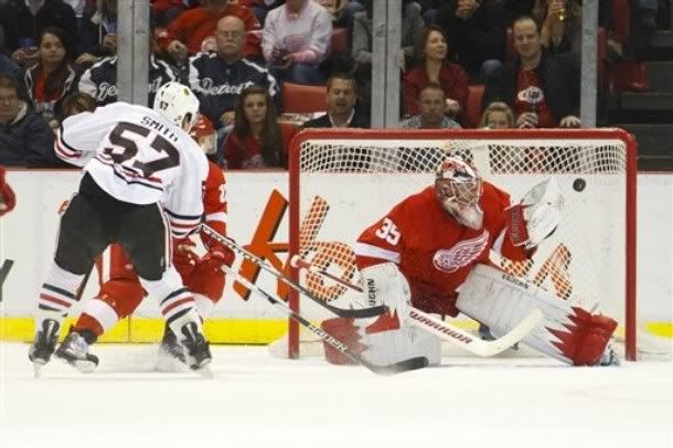 Chicago Blackhawks center Ben Smith (57) scores a goal on Detroit Red Wings goalie Jimmy Howard (35) in the first period of an NHL hockey game in Detroit, Friday, April 8, 2011.