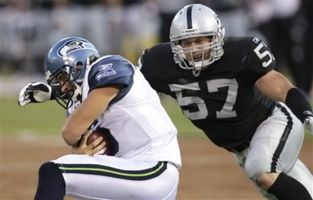 Seattle Seahawks quarterback Charlie Whitehurst, left, is tackled by Oakland Raiders linebacker Ricky Brown (57) while scrambling in the first quarter of an NFL preseason football game in Oakland, Calif. , Thursday, Sept. 2, 2010.