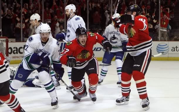 Chicago Blackhawks Ben Smith (C) reacts with teammate Marian Hossa (R) after his game-winning goal against the Vancouver Canucks in overtime of Game 6 in their NHL Western Conference quarter-final hockey game in Chicago, April 24, 2011. On the left is Vancouver Canucks Daniel Sedin.