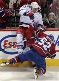 Montreal Canadiens' Mathieu Darche (52) checks New York Rangers center Andre Deveaux (33) during third period NHL hockey action in Montreal November 19, 2011.