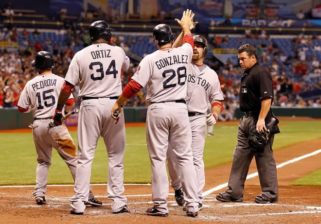 : Infielder Kevin Youkilis(notes) #20 of the Boston Red Sox is congratulated by Adrian Gonzalez(notes) #28, David Ortiz(notes) #34 and Dustin Pedroia(notes) #15 after his three run home run in the seventh inning against the Tampa Bay Rays during the game at Tropicana Field on June 15, 2011 in St. Petersburg, Florida. 