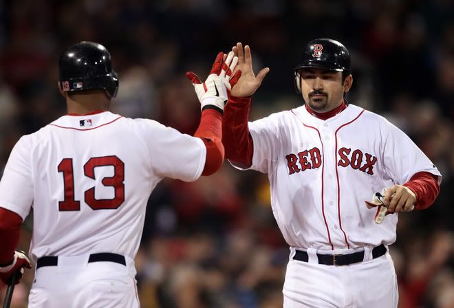 Adrian Gonzalez(notes) #28 of the Boston Red Sox is congratulated by teammate Carl Crawford(notes) #13 after Gonzalez scored in the fourth inning against the Chicago Cubs on May 22, 2011 at Fenway Park in Boston, Massachusetts.