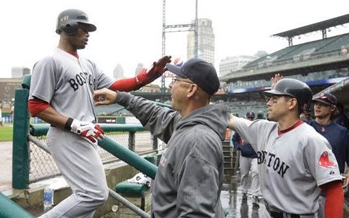 Boston Red Sox's Carl Crawford, left, is congratulated by coach Terry Francona, center, after scoring from third on a Josh Reddick single during the eighth inning of a baseball game against the Detroit Tigers in Detroit, Thursday, May 26, 2011.