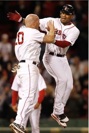 Boston Red Sox's Carl Crawford, right, jumps with teammate Kevin Youkilis after Crawford' hit drove in the winning run against the Minnesota Twins during the 11th inning of Boston's 2-1 win in a baseball game at Fenway Park in Boston on Monday, May 9, 2011. 