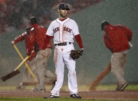 Boston Red Sox second baseman Dustin Pedroia(notes) stands in the infield as grounds crew rake and pour dirt just before a rain delay in the eighth inning of a baseball game against the Detroit Tigers at Fenway Park in Boston Wednesday, May 18, 2011.