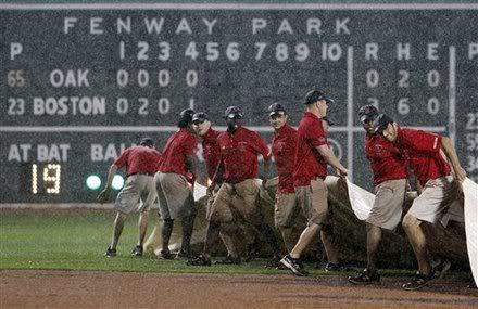 Grounds crew member roll out the tarp in the fifth inning of the second game of a baseball doubleheader between the Boston Red Sox and the Oakland Athletics in a baseball game in Boston, Saturday, Aug. 27, 2011.