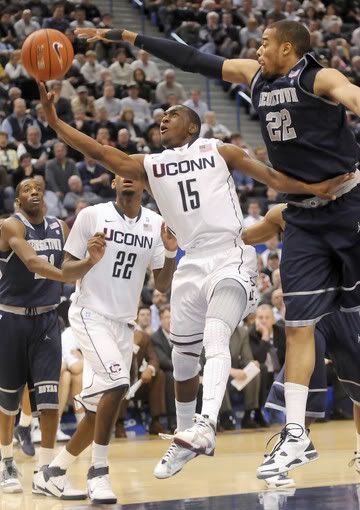 UConn's Kemba Walker keeps Julian Vaughn of Georgetown at arm's length as he drives to the basket for two of his game-high 31 points. Walker also dished out 10 assists and had seven rebounds in a 78-70 victory at the XL Center Wednesday night in Hartford.