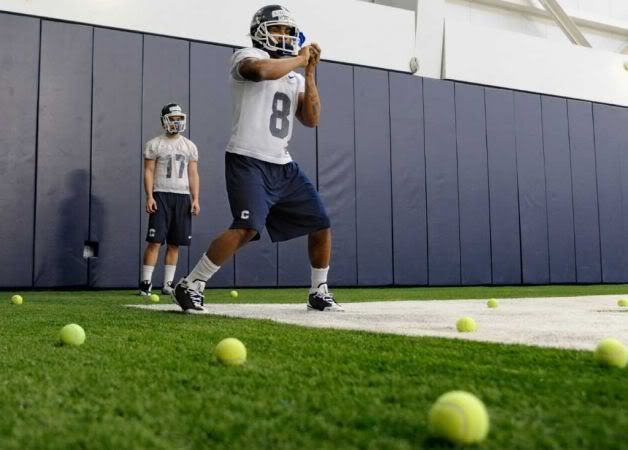 Connecticut wide receiver Leon Kinnard (8) catches tennis balls thrown toward him from a machine while teammate Frank Guardi (17) looks on during the first day of spring NCAA college football practice in Storrs, Conn., Tuesday, March 15, 2011