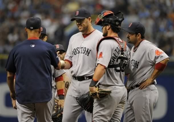 Boston Red Sox catcher Jarrod Saltalamacchia, second from right, and first baseman Adrian Gonzalez, right, look on as manager Terry Francona, left, takes pitcher John Lackey, center, off the mound during the sixth inning of a baseball game against the Tampa Bay Rays, Saturday, July 16, 2011, in St. Petersburg, Fl