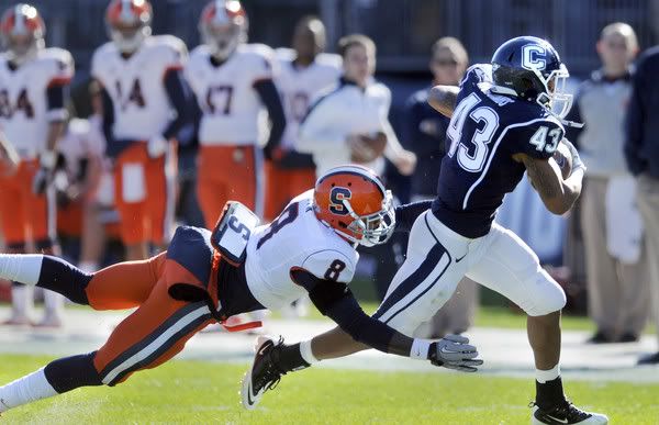 UConn's Lyle McCombs makes some yardage in the 1st quarter before being brought down by Syracuse's Keon Lyn. 