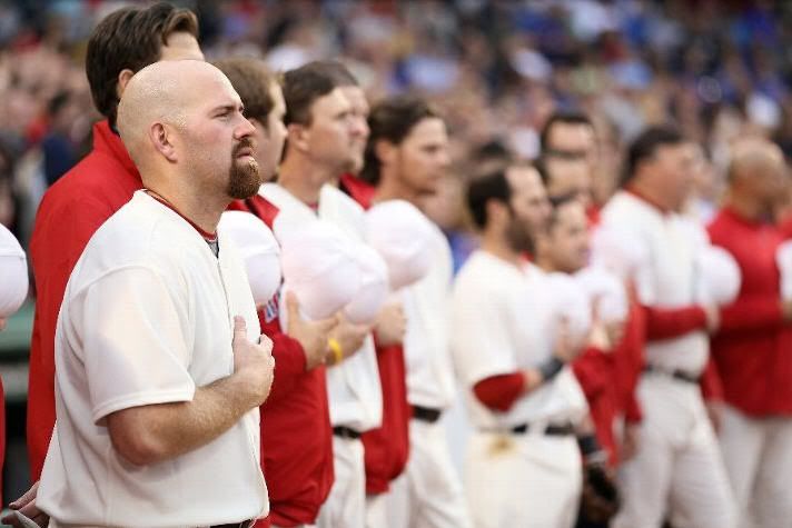 Kevin Youkilis #20 of the Boston Red Sox stands with his teammates during the national anthem before the game against the Chicago Cubs on May 21, 2011 at Fenway Park in Boston, Massachusetts.