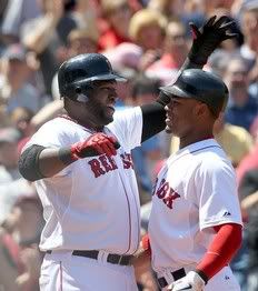 Carl Crawford #13 of the Boston Red Sox celebrates his three-run home run with teammate David Ortiz #34 against the Oakland Athletics at Fenway Park on June 5, 2011 in Boston, Massachusetts
