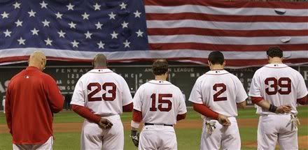 As a giant U.S. flag drops across the left field wall, Boston Red Sox pause for a moment of silence prior to facing the Los Angeles Angels in a baseball game in Boston, Monday, May 2, 2011. The Red Sox honored those who died on Sept. 11, 2001, a day after the raid on Osama bin Laden's compound in Pakistan