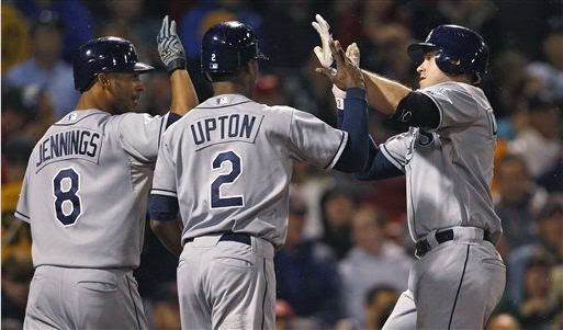 Tampa Bay Rays' Evan Longoria, right, is congratulated by teammates B.J. Upton, center, and Desmond Jennings after his three-run home run against the Boston Red Sox in the third inning of a baseball game at Fenway Park in Boston, Thursday, Sept. 15, 2011.