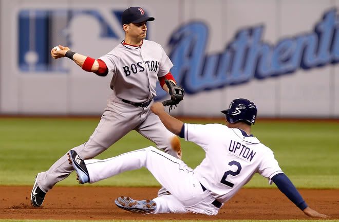Shortstop Marco Scutaro(notes) #10 of the Boston Red Sox turns a double play as B.J. Upton(notes) #2 of the Tampa Bay Rays tries to break it up during the game at Tropicana Field on July 16, 2011 in St. Petersburg, Florida