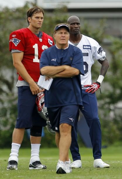 New England Patriots quarterback Tom Brady (L), wide receiver Chad Ochocinco (R) and head coach Bill Belichick watch a drill during the afternoon practice session of their NFL training camp in Foxborough, Massachusetts July 29, 2011.
