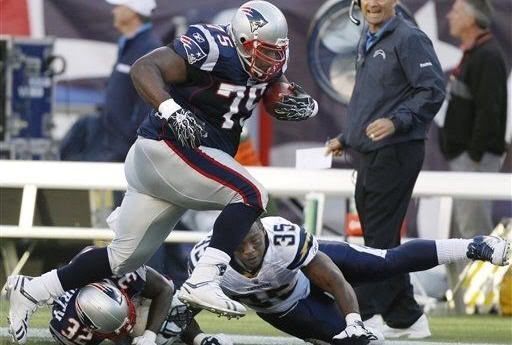 New England Patriots nose tackle Vince Wilfork (75) runs over cornerback Devin McCourty (32) with the football after intercepting a pass as San Diego Chargers running back Mike Tolbert (35) reaches out to bring him down in the second quarter of an NFL fooball game Foxborough, Mass., Sunday, Sept. 18, 2011.