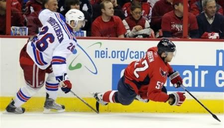 Washington Capitals defenseman Mike Green (52) falls to the ice against New York Rangers center Erik Christensen (26) during the first period in Game 1 of a first-round NHL hockey playoff series on Wednesday, April 13, 2011, in Washington. The Capitals won 2-1 in overtime.