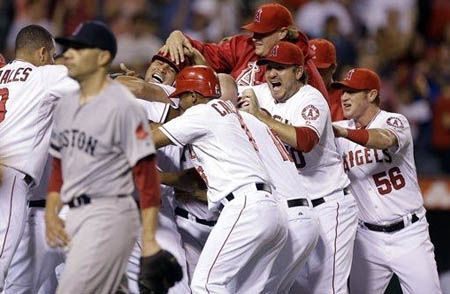 Boston Red Sox relief pitcher Alfredo Aceves walks off the field as the Los Angeles Angels celebrate after giving up the game winning sacrifice fly to Los Angeles Angels' Torii Hunter during bottom of the ninth inning of an baseball in Anaheim, Calif. Tuesday, Aug. 28, 2012 