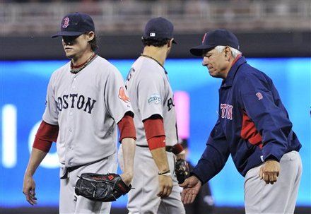 Boston Red Sox manager Bobby Valentine, right, gives a tap to pitcher Clay Buchholz, left, as Buchholz left the baseball game in the sixth inning after loading the bases with a walk to the Minnesota Twins on Wednesday, April 25, 2012, in Minneapolis.