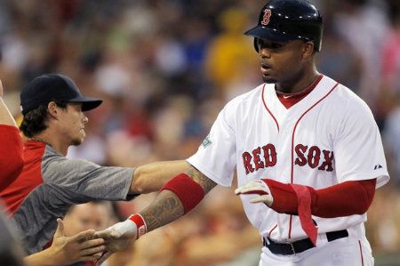 Boston Red Sox's Carl Crawford is welcomed to the dugout after scoring on a double hit by Adrian Gonzalez in the third inning of a baseball game at Fenway Park in Boston, Monday, Aug. 6, 2012.