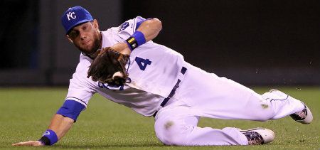 Alex Gordon #4 of the Kansas City Royals makes a sliding catch during the 9th inning of the game against the Boston Red Sox on May 9, 2012 at Kauffman Stadium in Kansas City, Missouri.