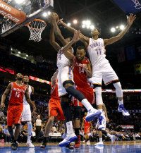 Oklahoma City 's Hasheem Thabeet (34) an Jeremy Lamb (11) defend the basket over Houston's Daequan Cook (14) during the NBA basketball game between the Houston Rockets and the Oklahoma City Thunder at the Chesapeake Energy Arena on Wednesday, Nov. 28, 2012, in Oklahoma City, Okla