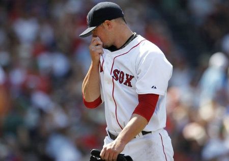 Boston Red Sox starting pitcher Jon Lester reacts as he walks back to the dugout during the fifth inning of American League MLB baseball action against the Toronto Blue Jays at Fenway Park in Boston, Massachusetts July 22, 2012.