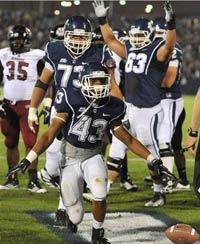 Connecticut's Lyle McCombs (43) celebrates his touchdown against Massachusetts in the first half of an NCAA college football game in East Hartford, Conn., Thursday, Aug. 30, 2012.